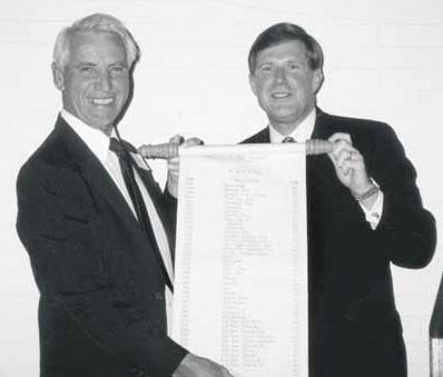 Mike Sherwood, left, and Leo A. Vecellio, Jr., hold a scroll filled with the many projects Mike worked on during his 50-plus years of service with Vecellio & Grogan. Even after retiring Mike continued assisting V&G with project supervision.