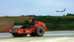 Jose Garnica-Sosa runs a compactor as a FedEx plane lands in the background. 