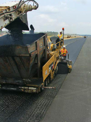 Paver Operator Angel Garcia, Screed Operator Alex Esquivel and the rest of the paving crew work on the airport runway and shoulder. 