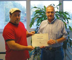Sharpe V.P. Ivan Clayton, right, presents Sean Smith with a 2012 Safety Phrase award for his entry: SAFETY: Were All Riding On it! Runner-up was Rob Williams of V&G. (Photo by John Riley, Jr.)