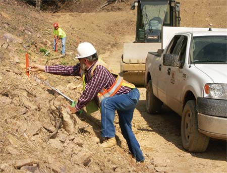 Foreman David Holly and Roller Operator Tonja Chandler check measurements in an area of fill. (Photo by Carl Thiemann)