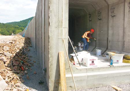 Junior Alkires spreads sealant between segments of a box culvert, which will be covered with backfill to bring the area up to grade. (Photo by Carl Thiemann)