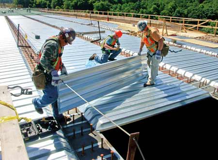 On Vecellio & Grogans East Beckley (WV) Bypass project, bridge crew members Manolo Rico, Jacob Hibbs and Chris McCune install stay-in-place forms prior to rebar placement and concrete pouring. (Photo by Carl Thiemann)