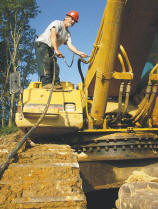 Service Truck Operator Les Lilly greases the fittings of an excavator equipped with a breaker hammer. (Photo by Carl Thiemann)