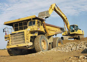 Hoe Operator Billy Wood furnishes a load of material to a Cat 777 haul truck operated by Robbie Drylie. (Photo by Carl Thiemann)