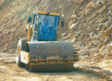 Roller Operator Evelyn Jarrell compacts fill in the area of the job known as the "wall project." (Photo by Carl Thiemann)