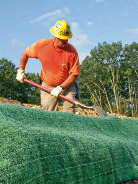 David McGuire packs dirt along the edge of the tiered wall project on Vecellio & Grogan's East Beckley Bypass project. (Photo by Carl Thiemann)