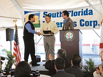 Juan Gonzales of Gonzales Construction, left, is congratulated by Facilities Manager Eddie Palenzuela and Vecenergy V.P. Todd Cannon.